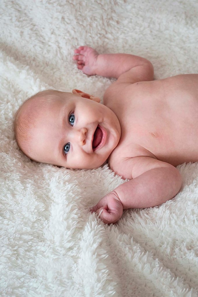 happy baby photoshoot nude on white blanket | Michaela Howe Photography