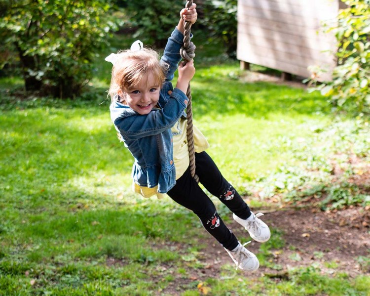 4 year old girl playing on rope swing, candid natural children portrait | Michaela Howe Photography